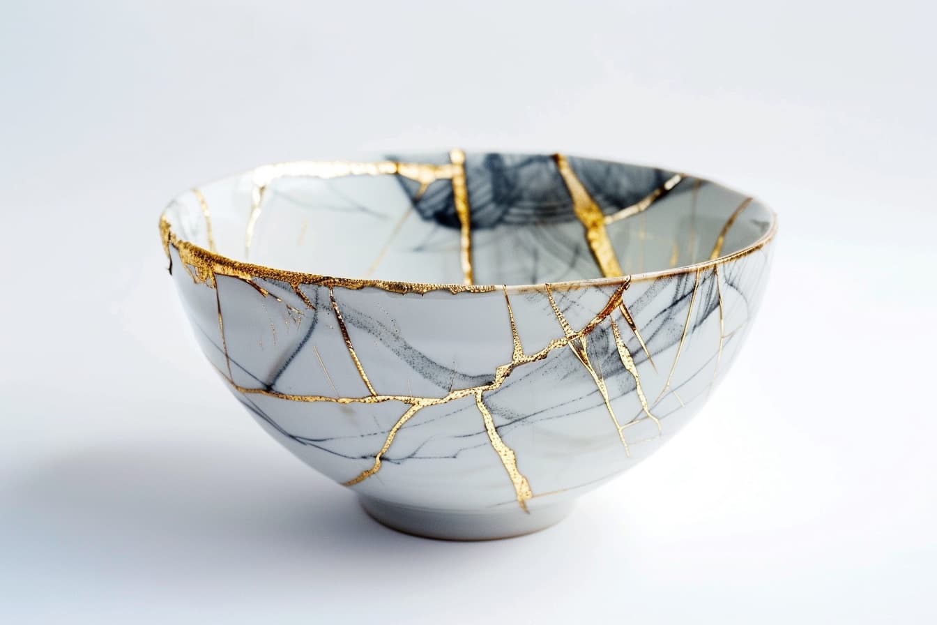 White ceramic bowl repaired with beautiful gold kintsugi seams